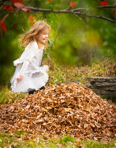 girl jumping in leaves